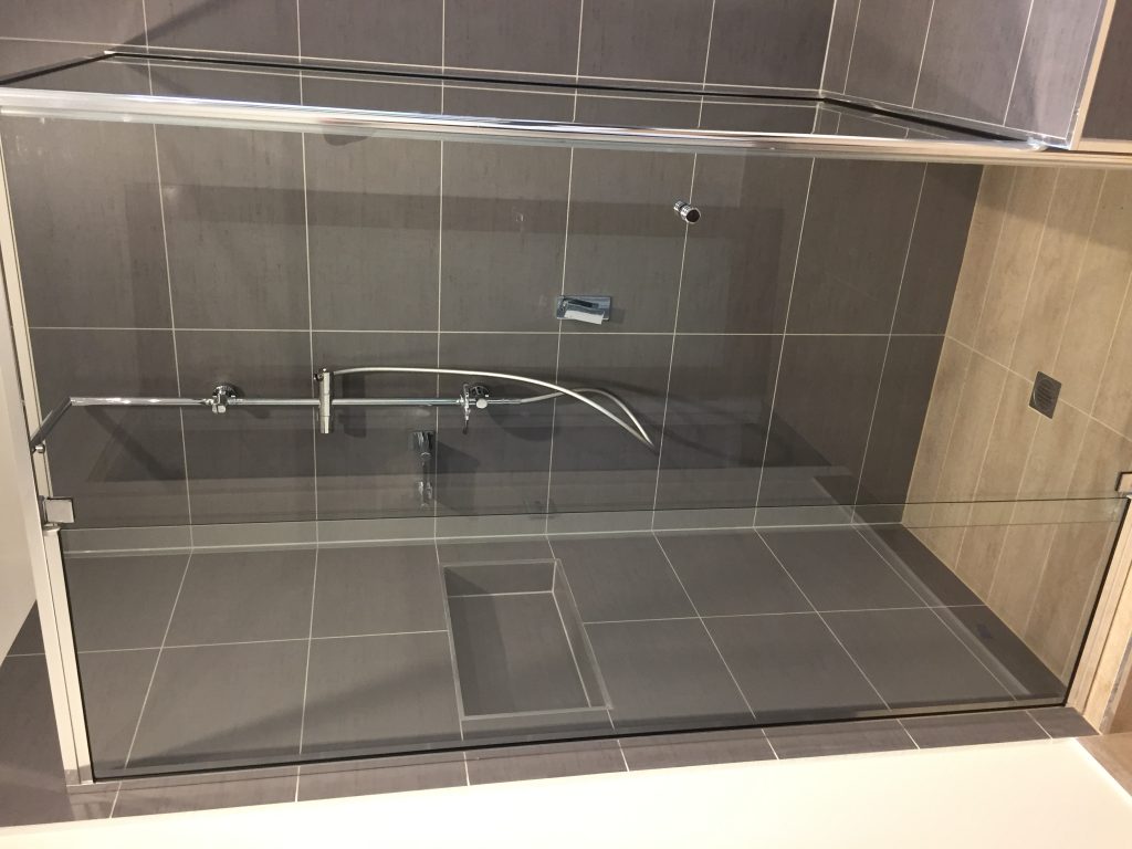 tiled shower adjoining bath hob timber look tiles