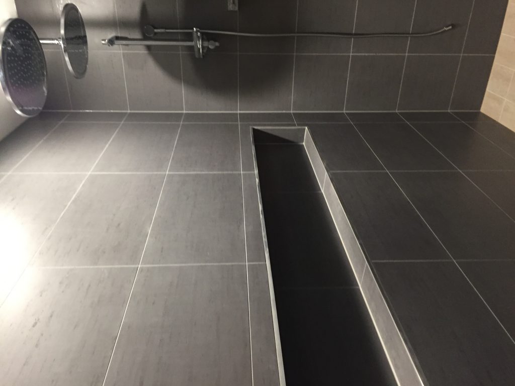 waterfall shower head and long recessed shelves tiles